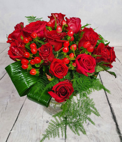 Średni bukiet z czerwonych krótkich róż z bogatym zielonym przybraniem