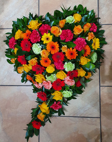 Duży wieniec w kształcie serca z kolorowych kwiatów